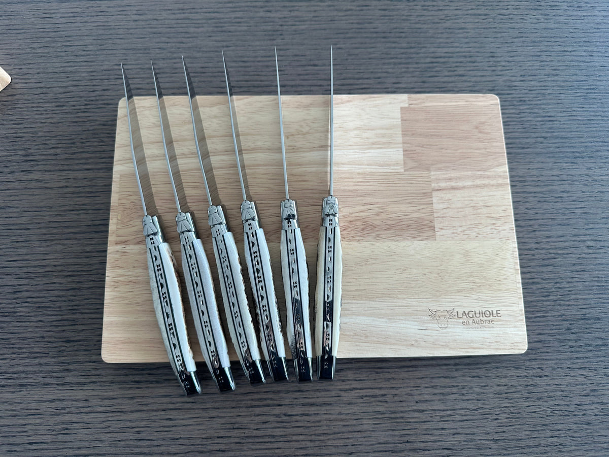 Six antler handled knives standing upright against the box