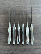 Six knives standing on end showing the antler texture