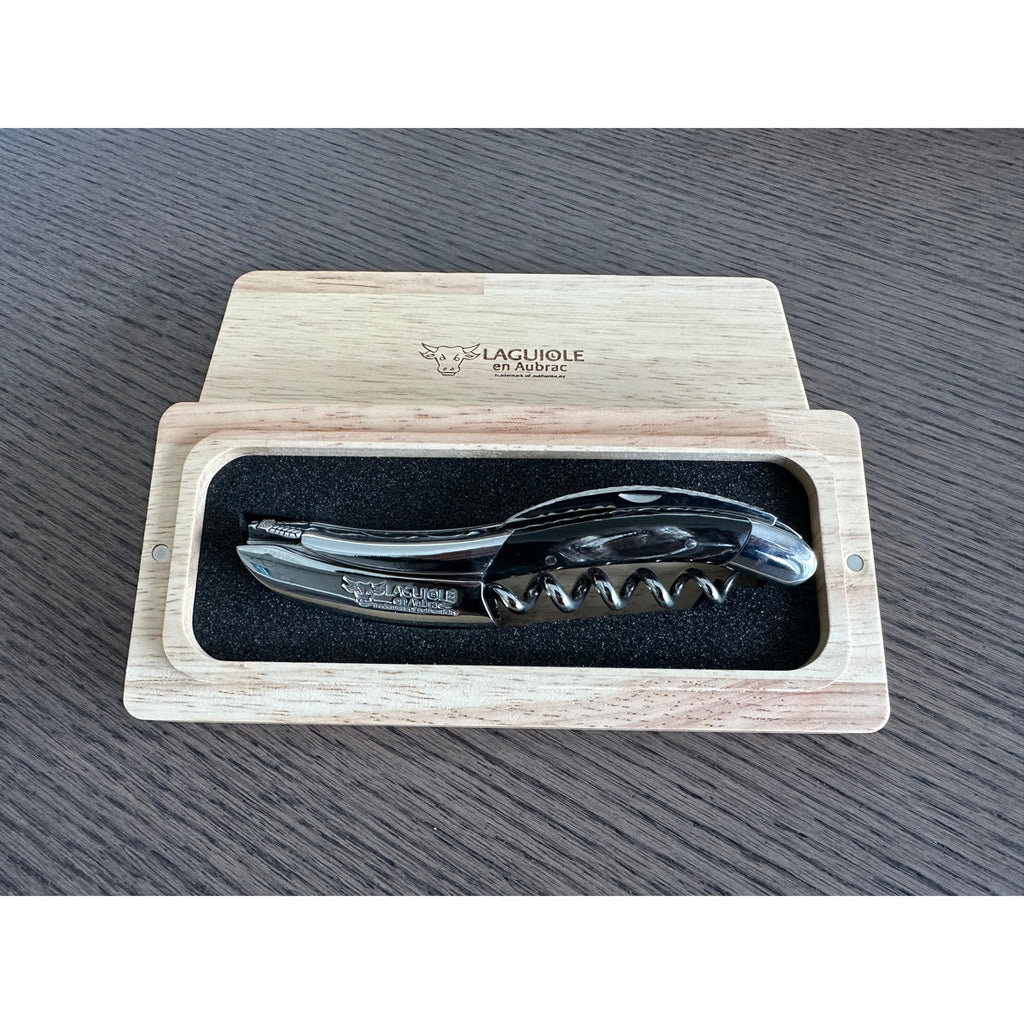 Buffalo horn corkscrew in an open oak gift box on a wood table