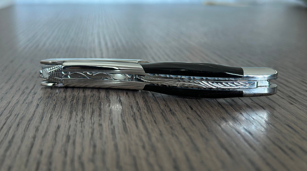 Side view of the folded corkscrew on a wood table