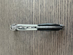Folded corkscrew lying on a wood table, spine facing up