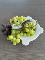 Corkscrew on a marble dish of green and red grapes