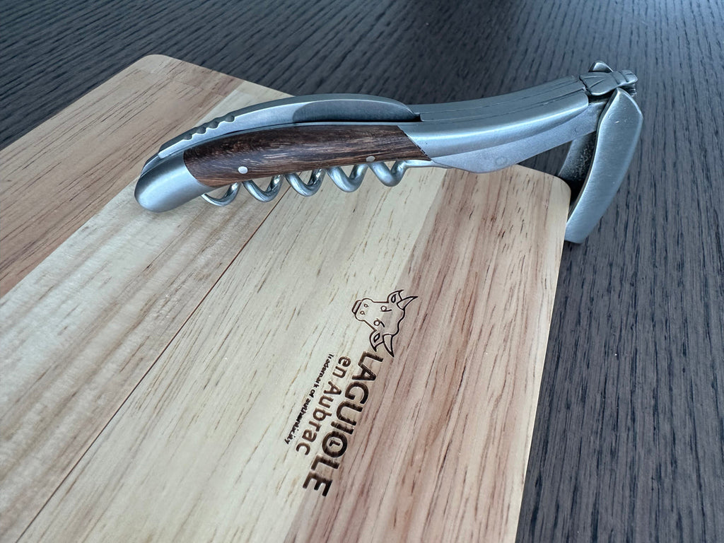Corkscrew resting on the oak box lid with the lever lifted