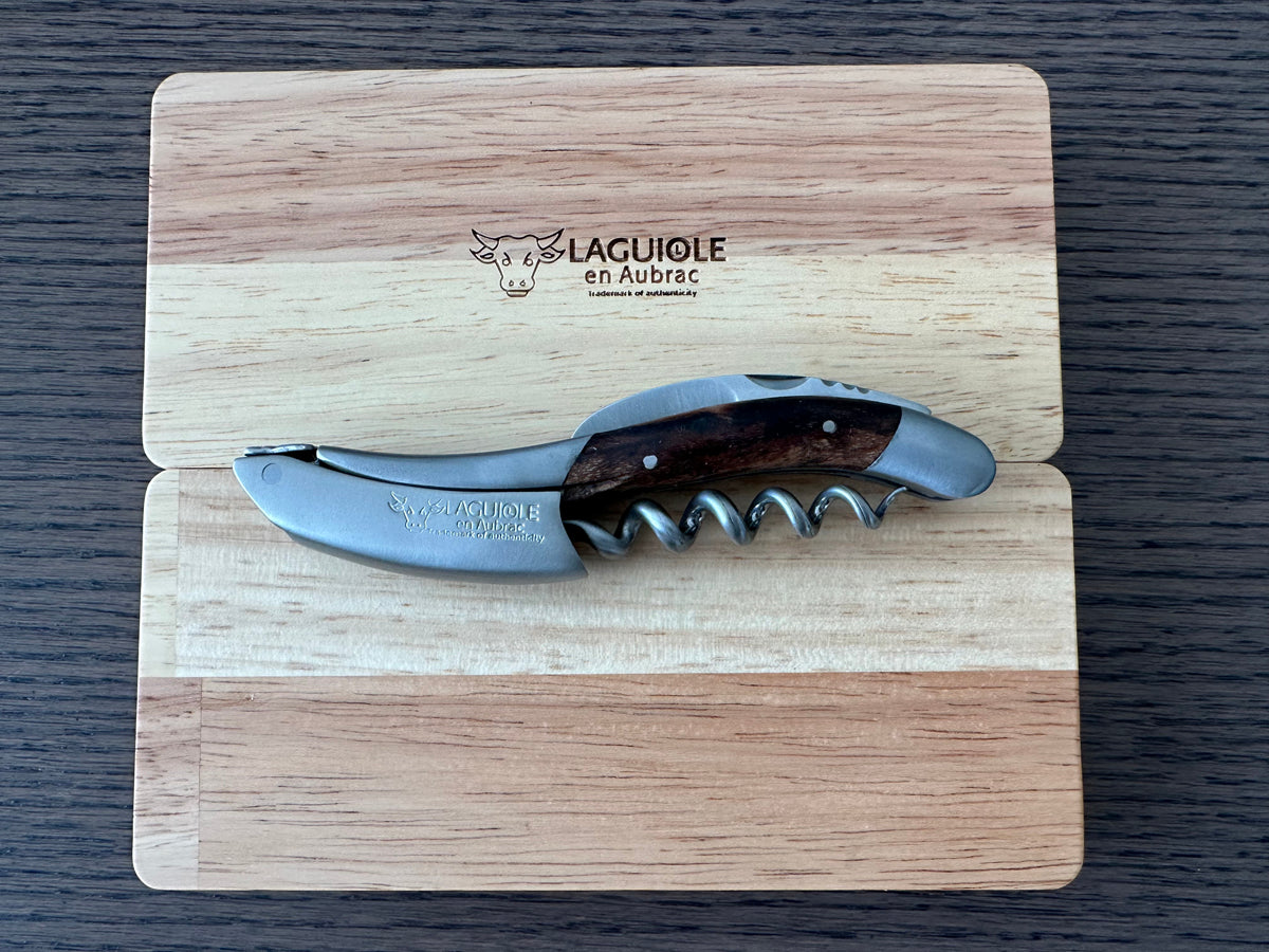 Corkscrew laid across the engraved Laguiole en Aubrac oak lid