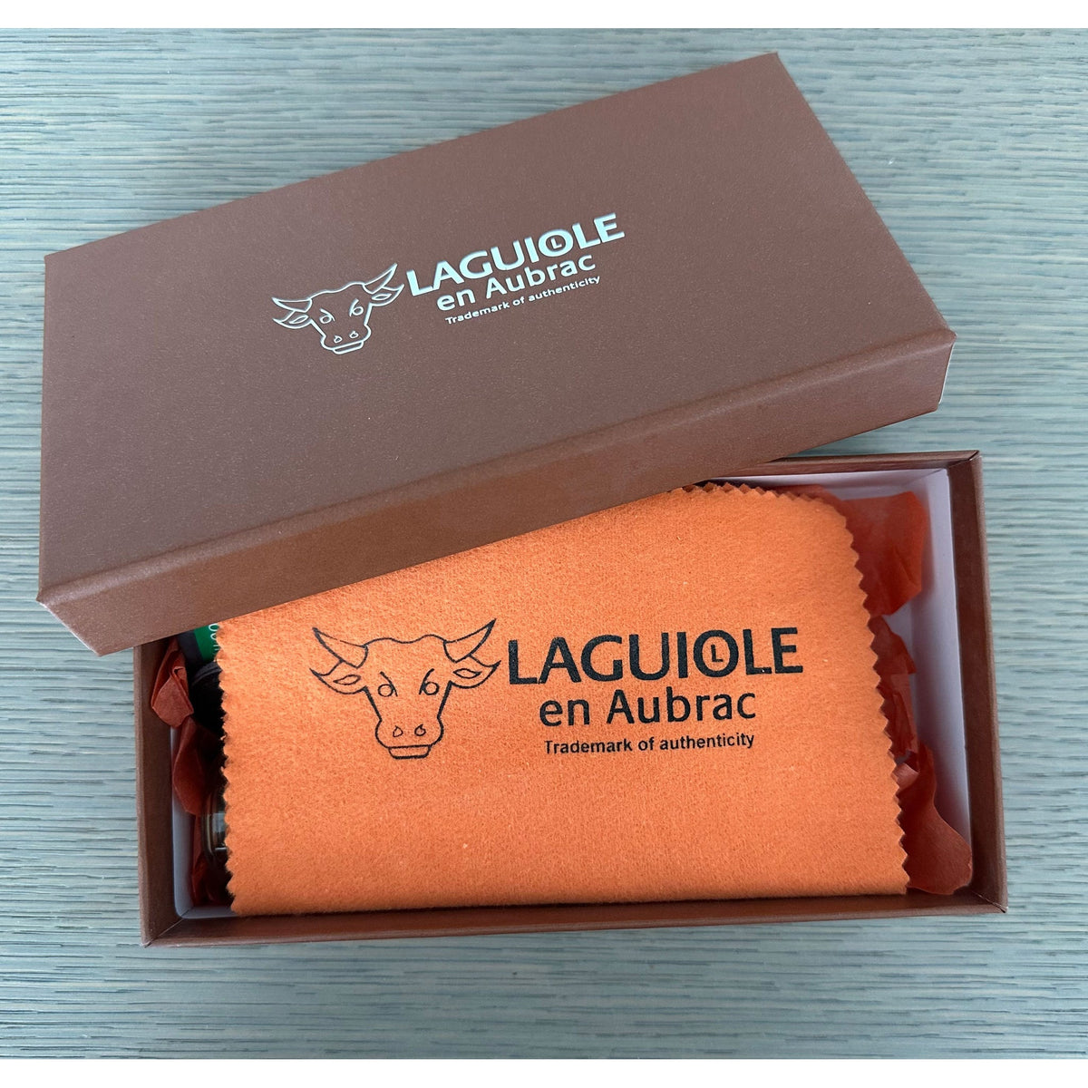 Open gift box with the orange Laguiole en Aubrac cleaning cloth inside