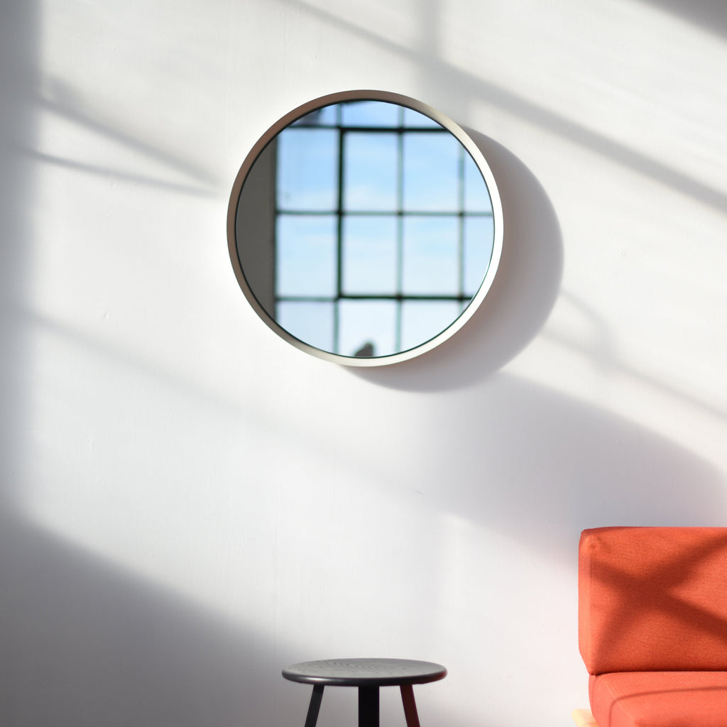 spun steel round mirror in a living room