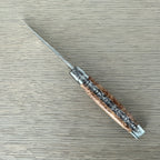 Open knife lying diagonally, showing the worked double plates