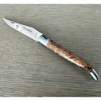 Open ash burl knife showing the engraved blade and bolster