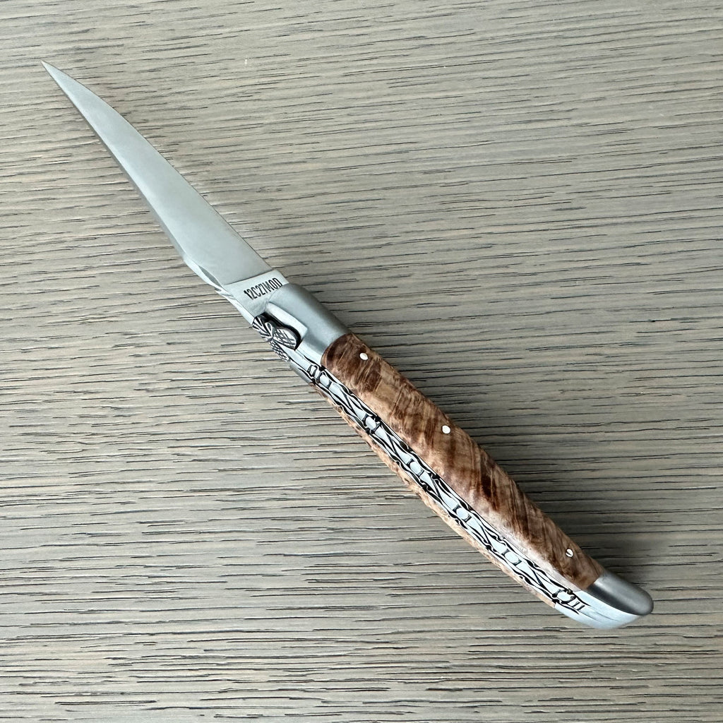 Close view of the brushed bolster and ash burl grain