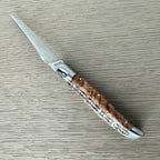 Close view of the brushed bolster and ash burl grain