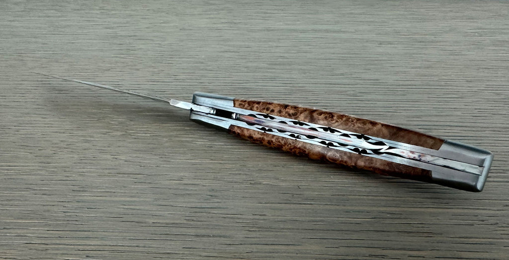 Closed knife seen along the back, showing the carved plates