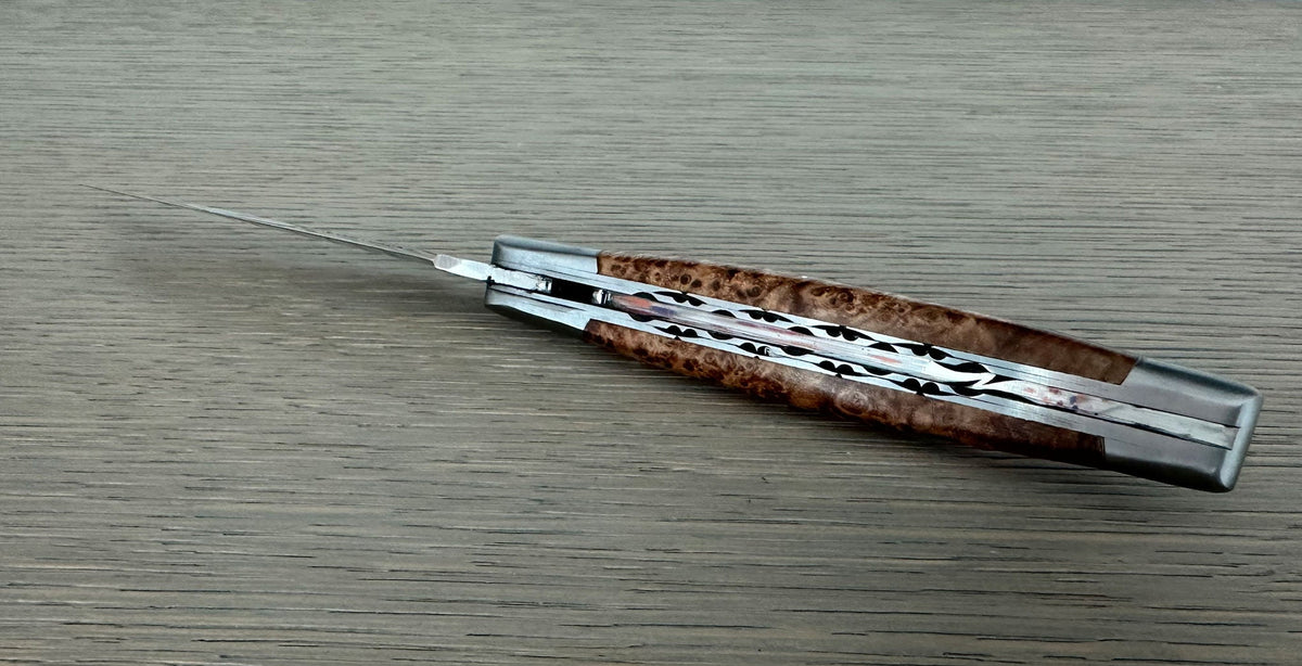 Closed knife seen along the back, showing the carved plates