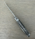 Open grey pakka knife lying diagonally, showing the filed plates
