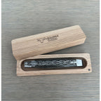 Closed knife resting in its open wooden storage box
