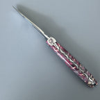 Open knife lying diagonally showing the engraved spring