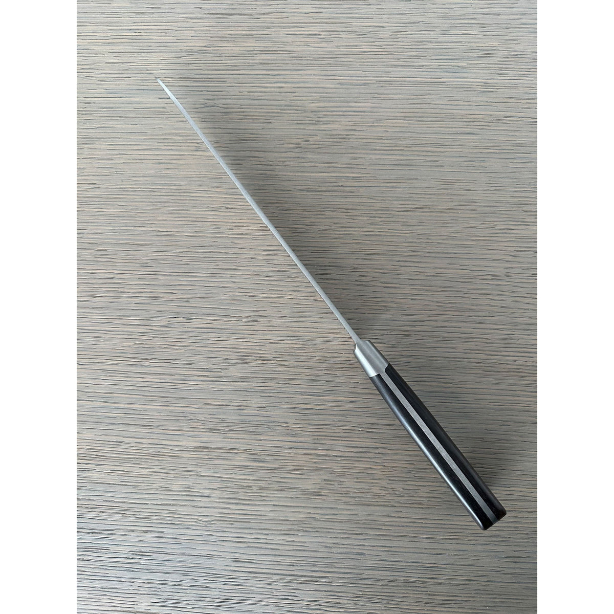 Bread knife seen diagonally from the handle end