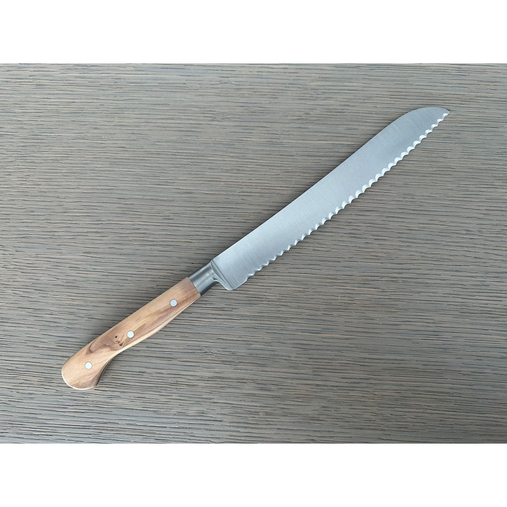 Bread knife lying with the serrated blade pointing up and right