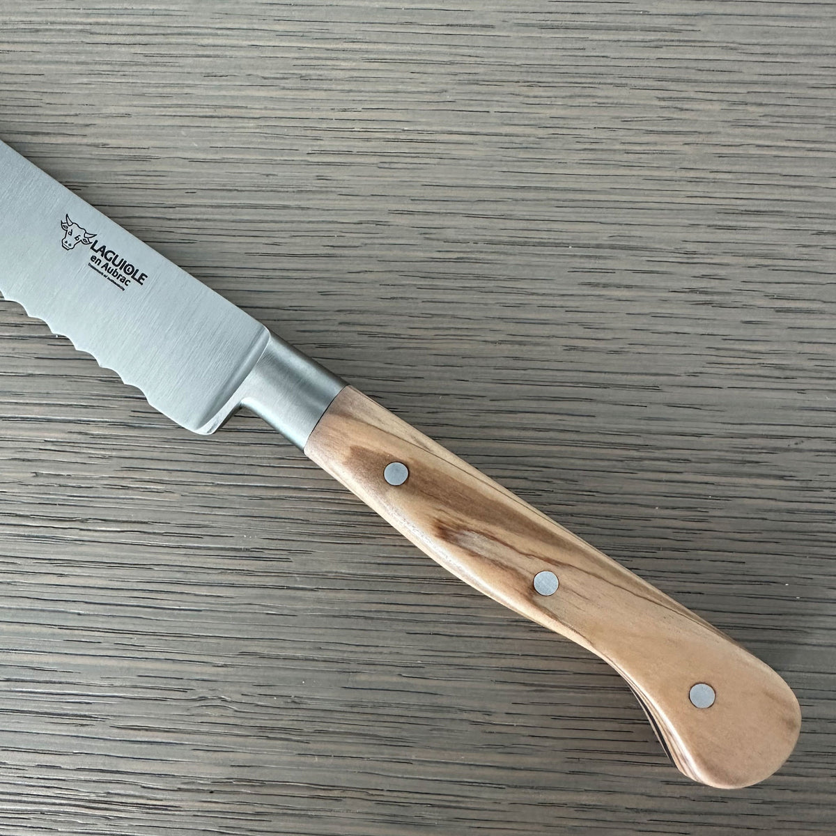 Close view of the triple rivet olive wood handle and bolster