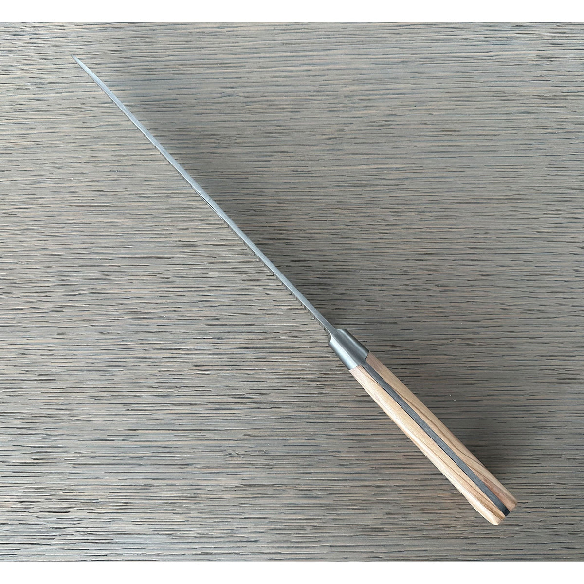 Bread knife seen diagonally from the handle end