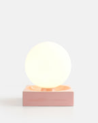 glossy ceramic globe lamp in Pink Glossy on a nightstand