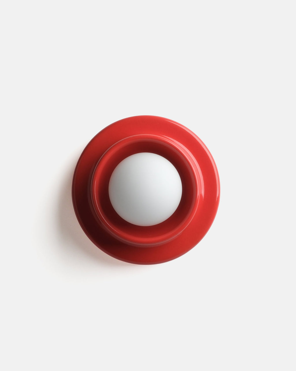 modern ceramic wall sconce in Red glaze beside a desk