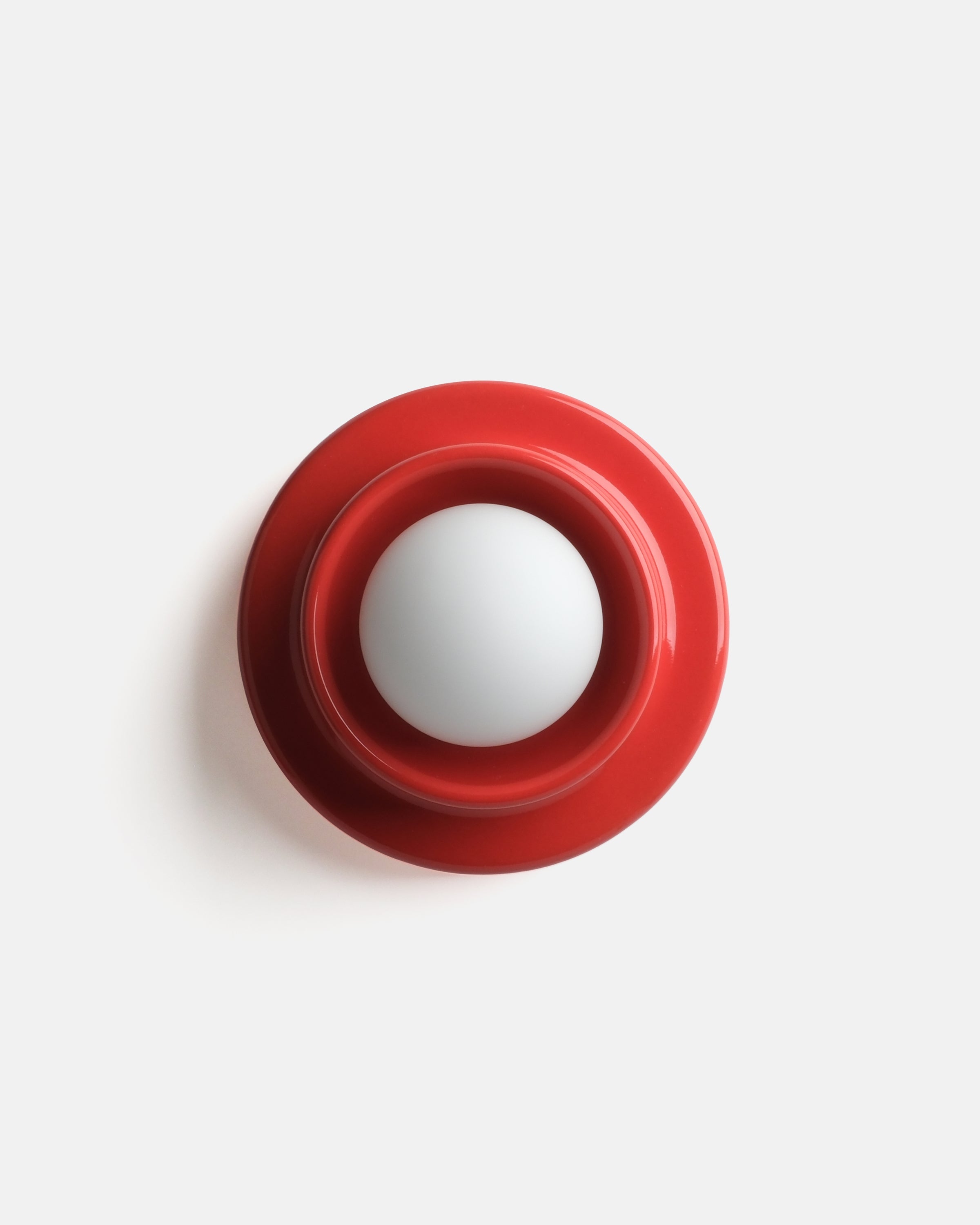 modern ceramic wall sconce in Red glaze beside a desk