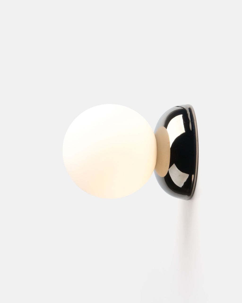 small chrome ripple sconce beside a bed