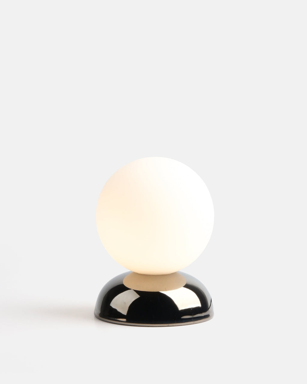 small chrome ripple table lamp on a bookshelf