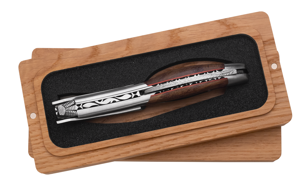 Corkscrew in the box showing the red lined carved spine