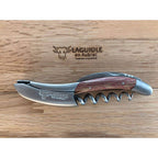 Red tinted wood corkscrew resting on the engraved Laguiole en Aubrac oak box