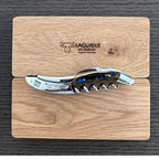 Blue cactus handled corkscrew laid on an engraved oak gift box