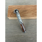 Folded corkscrew resting across the oak box