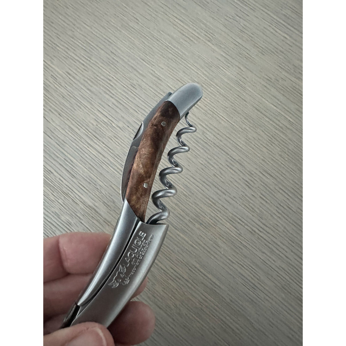 Hand holding the corkscrew with the spiral opened