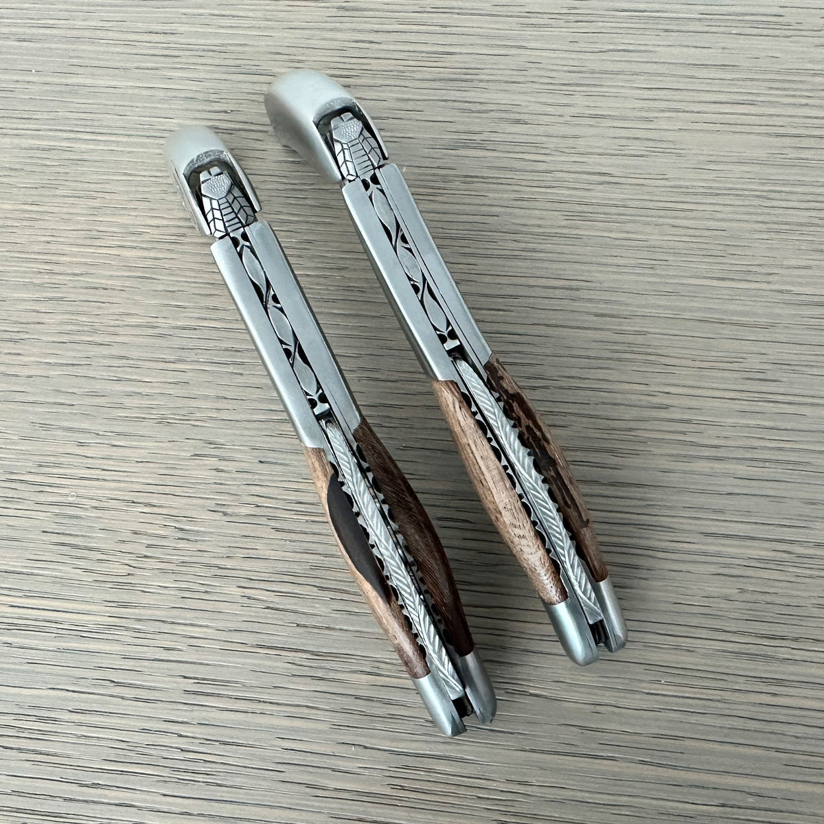 Two views of the folded corkscrew side by side on a grey surface
