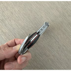 Hand opening the corkscrew to show the red lined spine