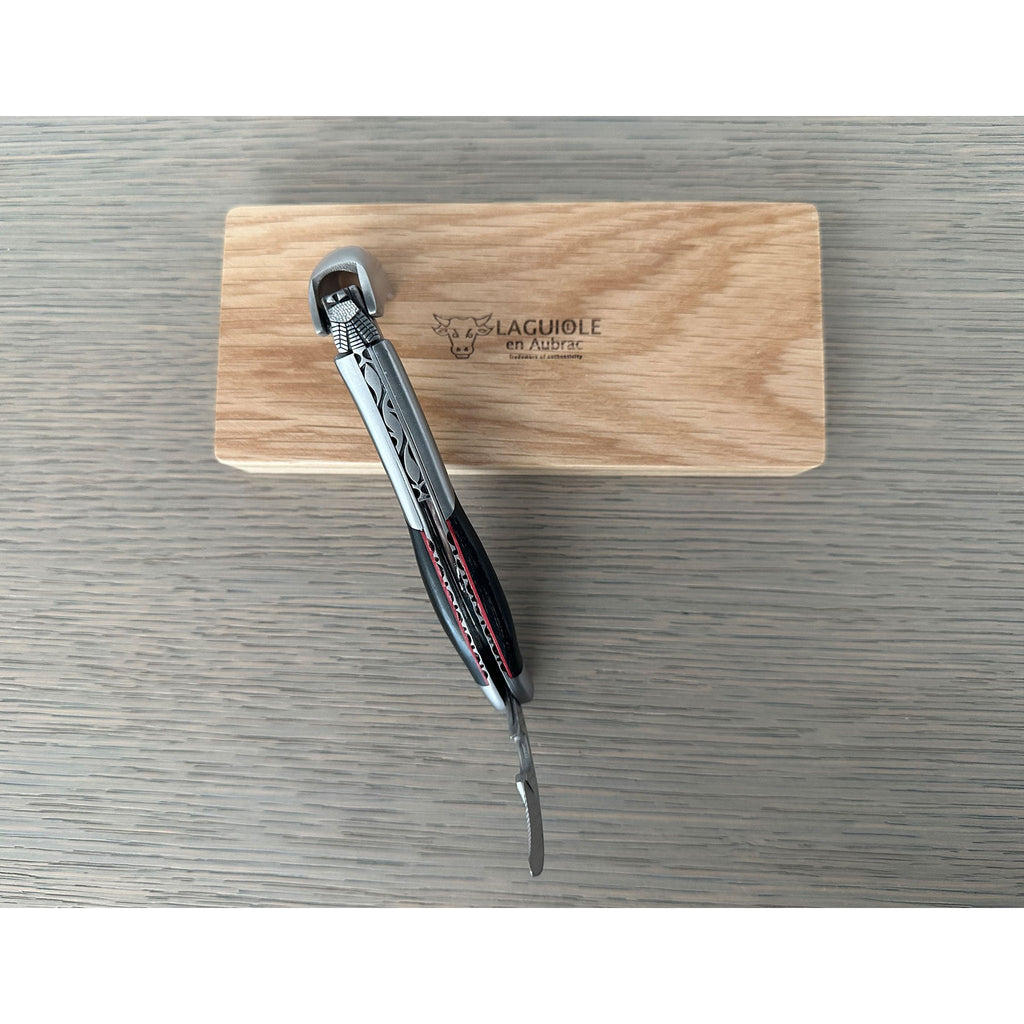 Folded corkscrew standing on the oak box