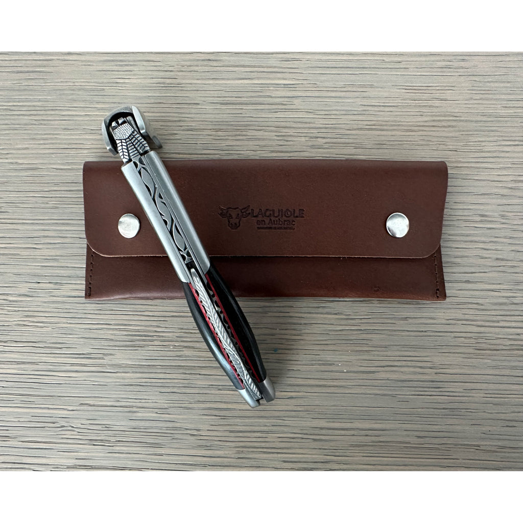 Corkscrew resting on its brown leather pouch