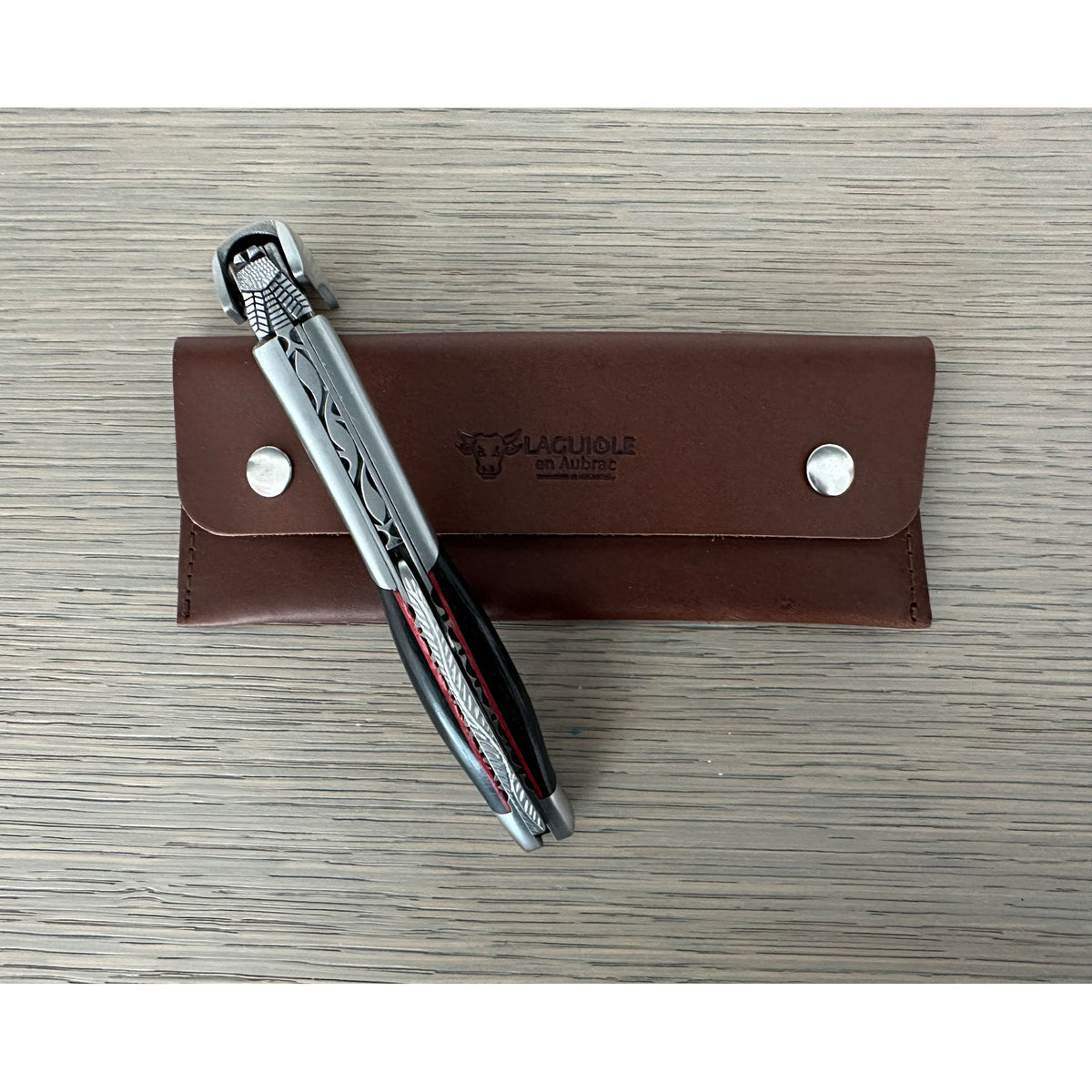 Corkscrew resting on its brown leather pouch