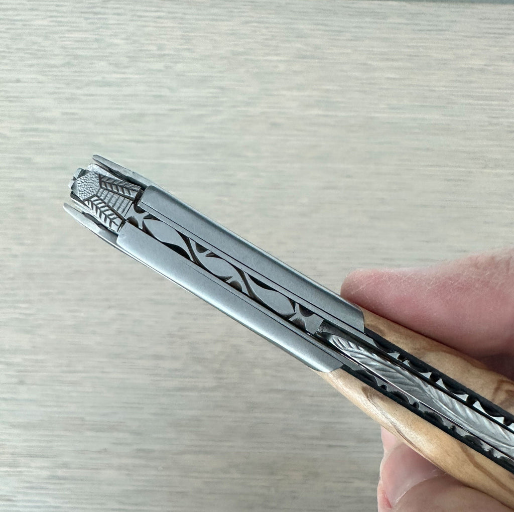 Hand holding the corkscrew close to show the carved steel spine