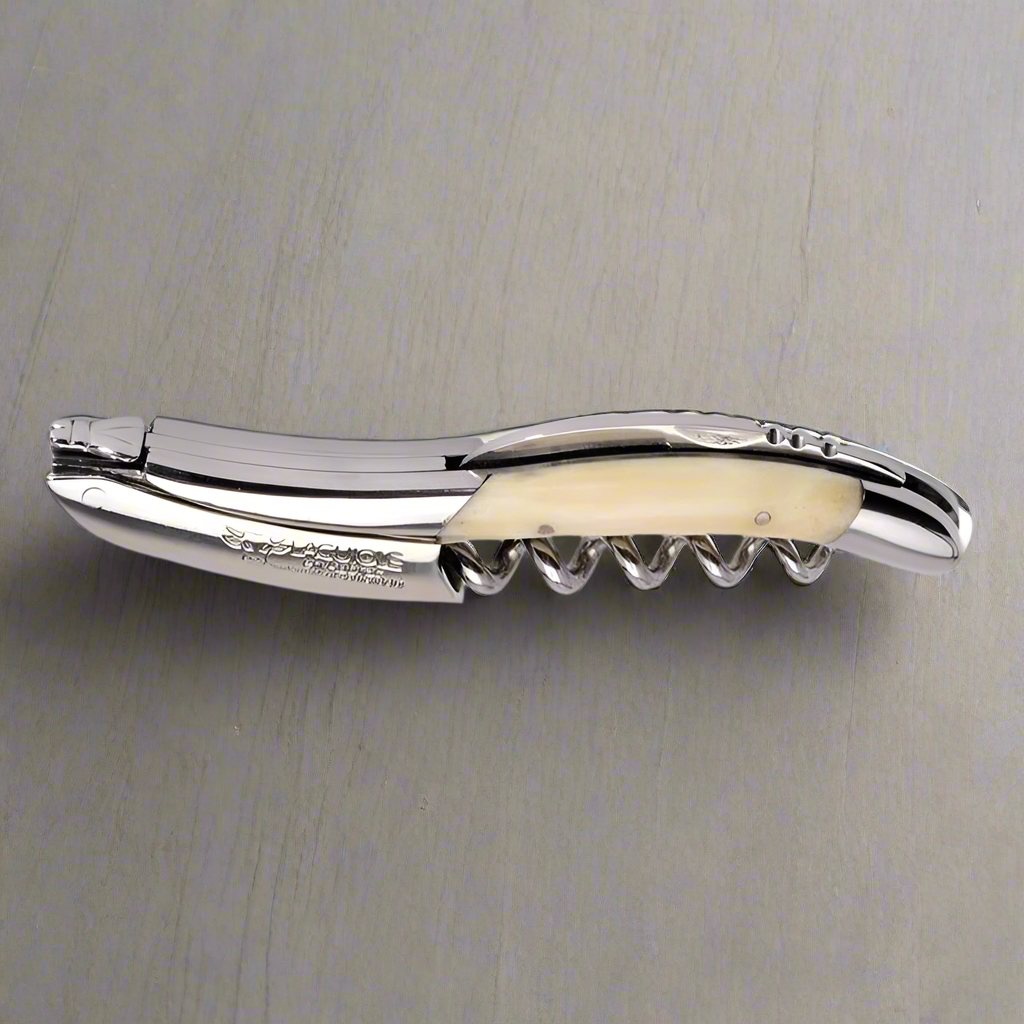 Folded zebu bone corkscrew on a grey surface