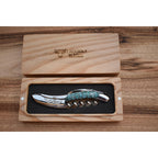 Turquoise handled corkscrew in an open oak gift box on a wood table