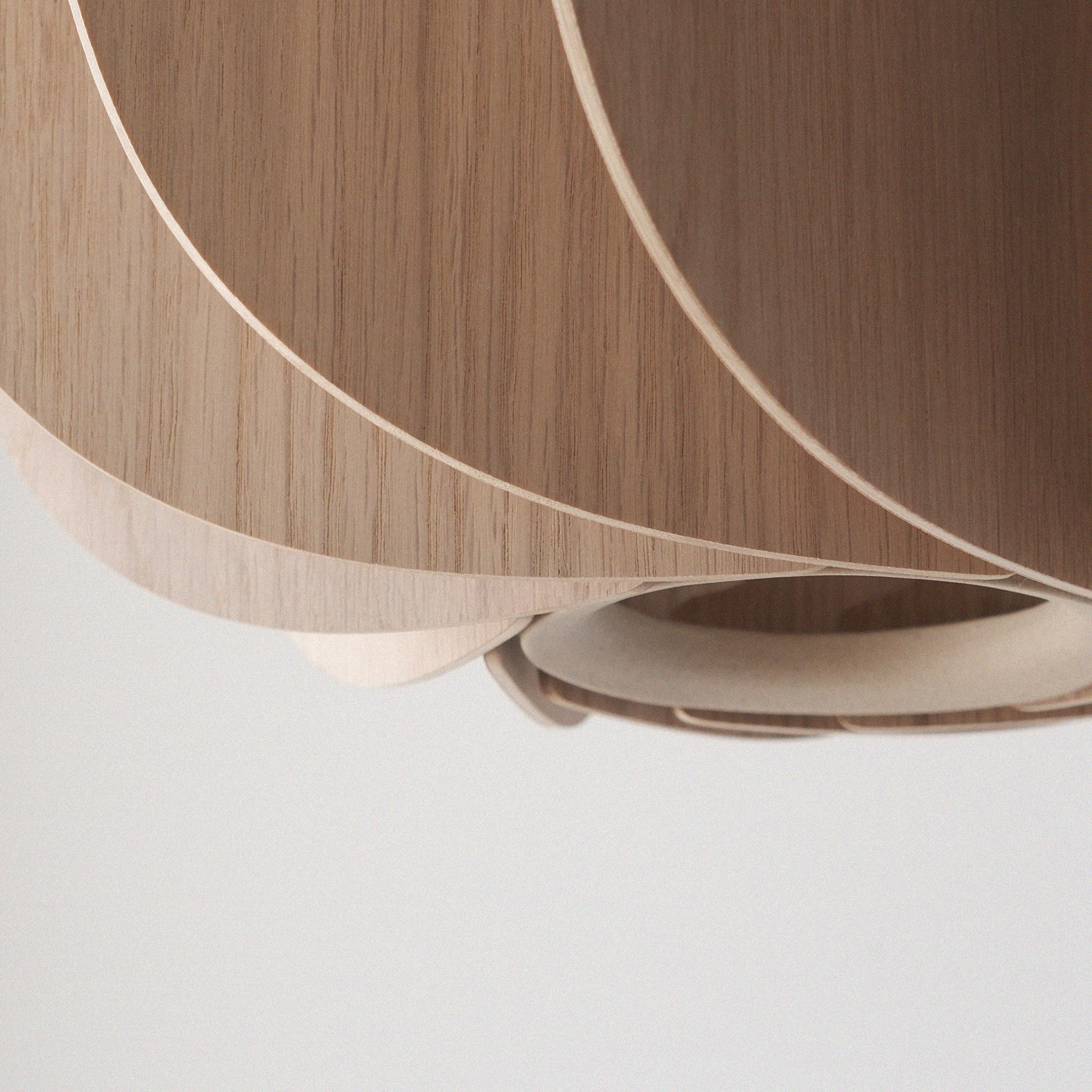 tall wood pendant light installed above a dining table