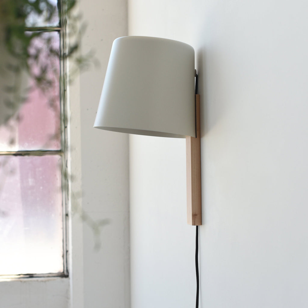 aluminum ceramic wall sconce beside a reading chair