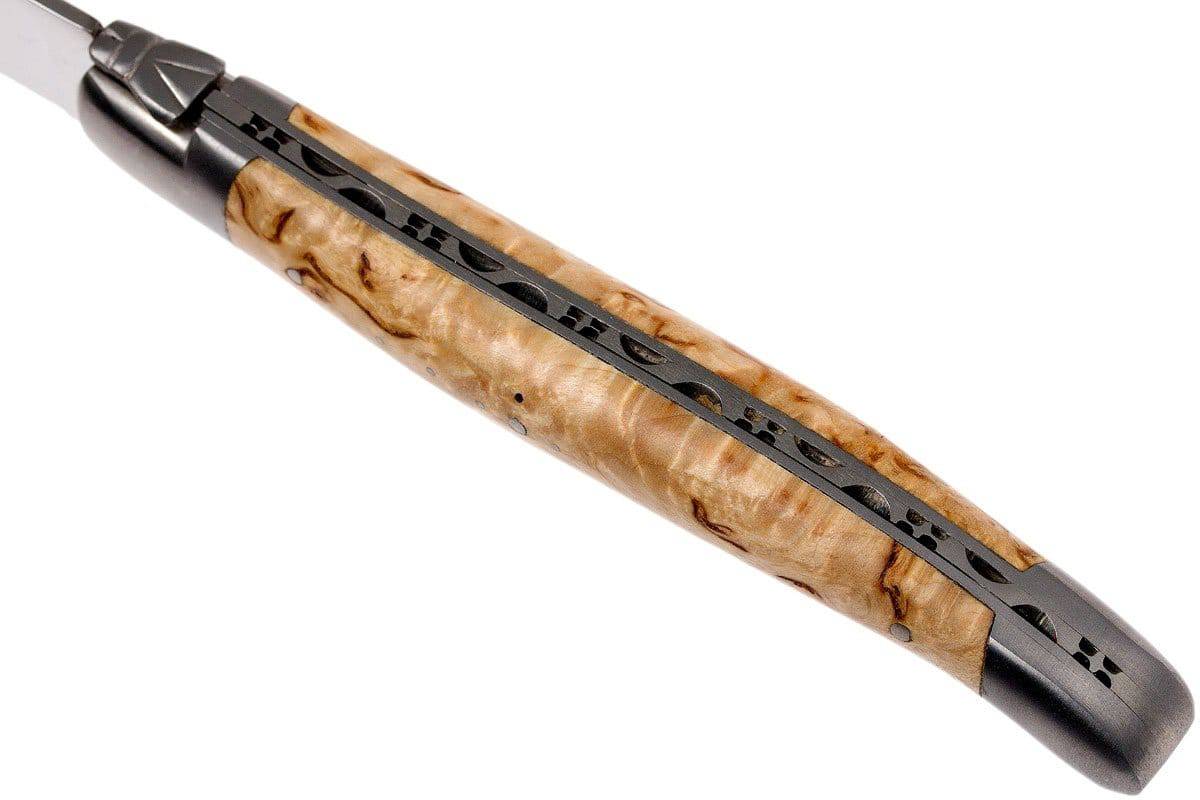 Close view of a pale birch handle and carved spine