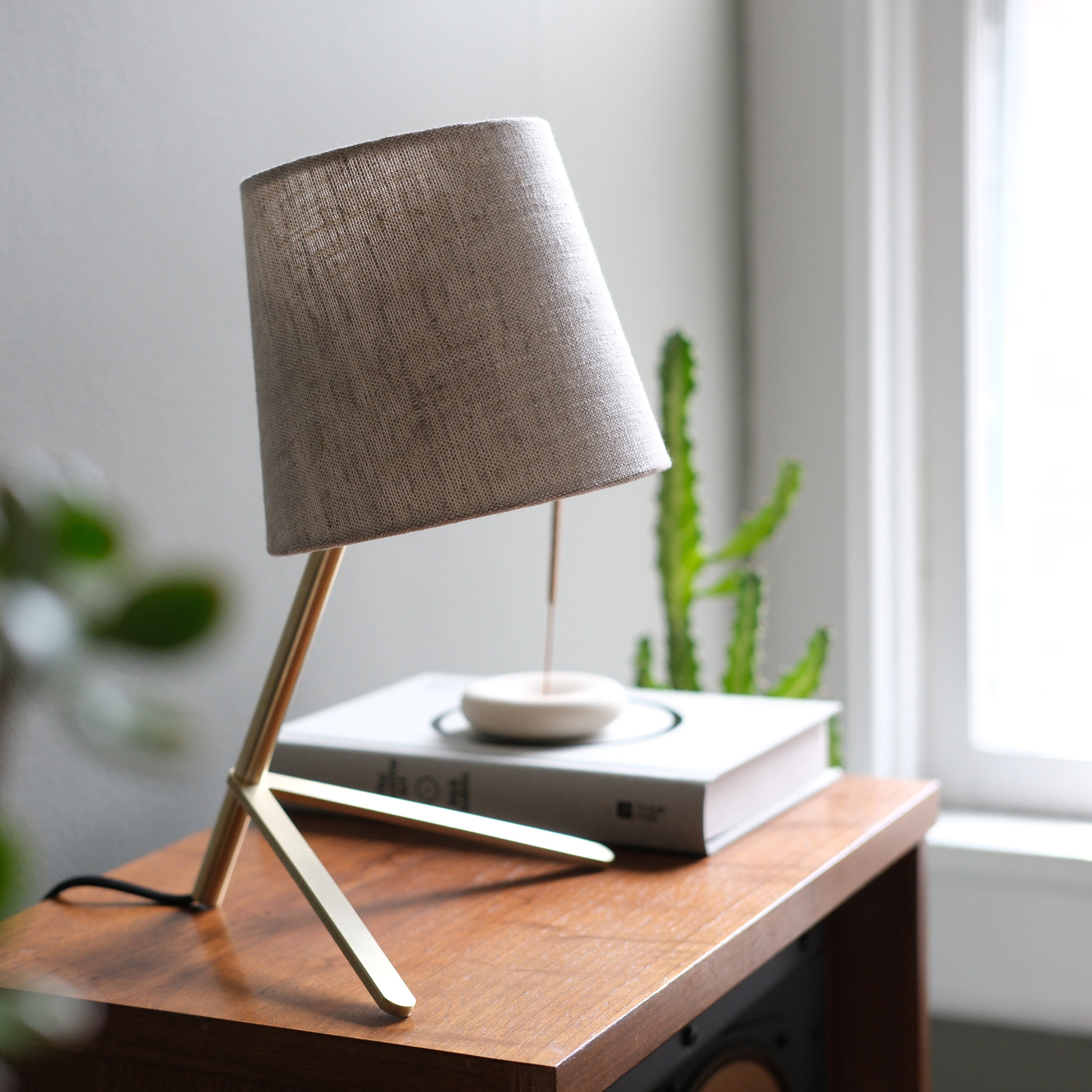 brass cotton shade desk lamp on a workspace