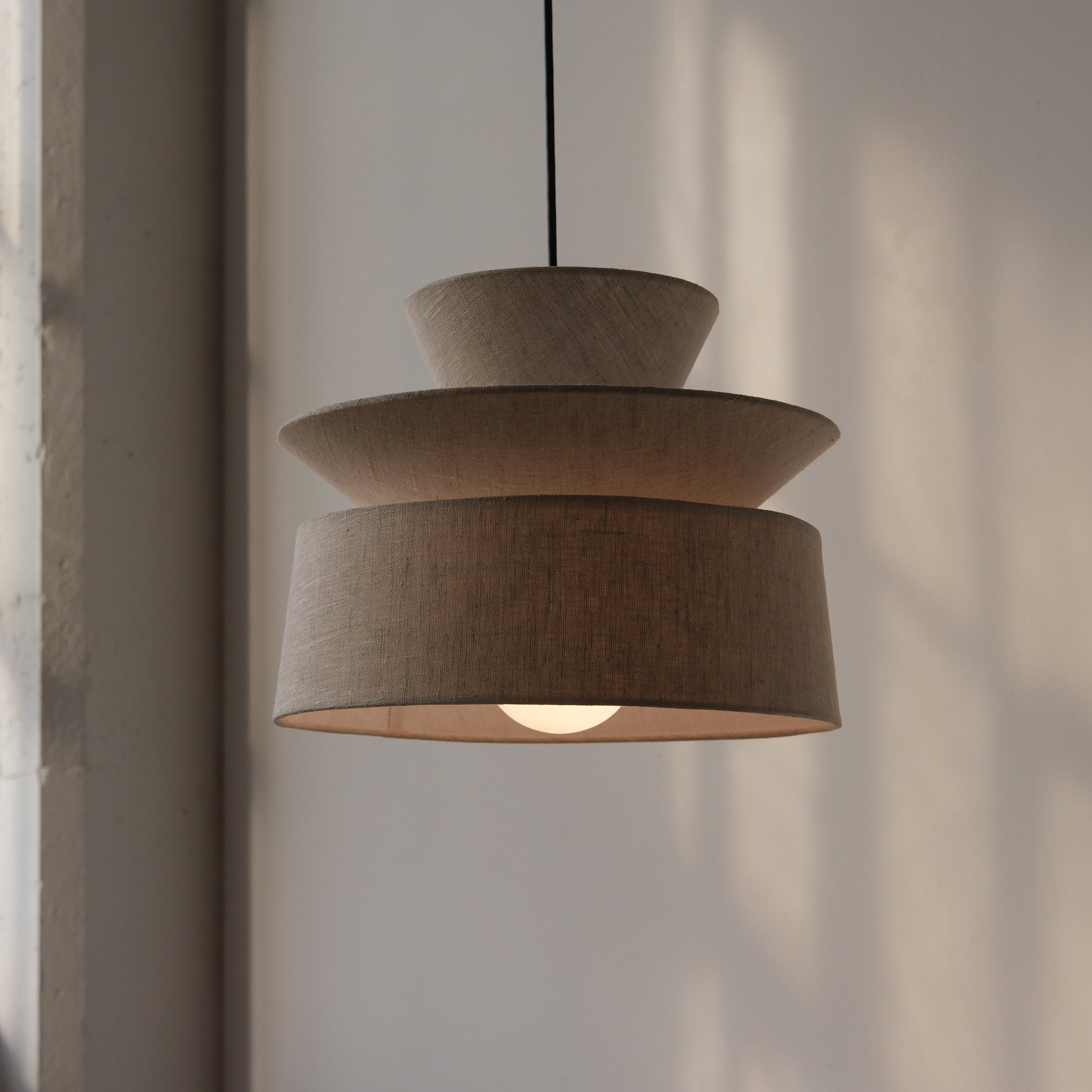cotton pendant lamp hanging over a dining table