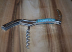 Corkscrew with the spiral open on a wooden board