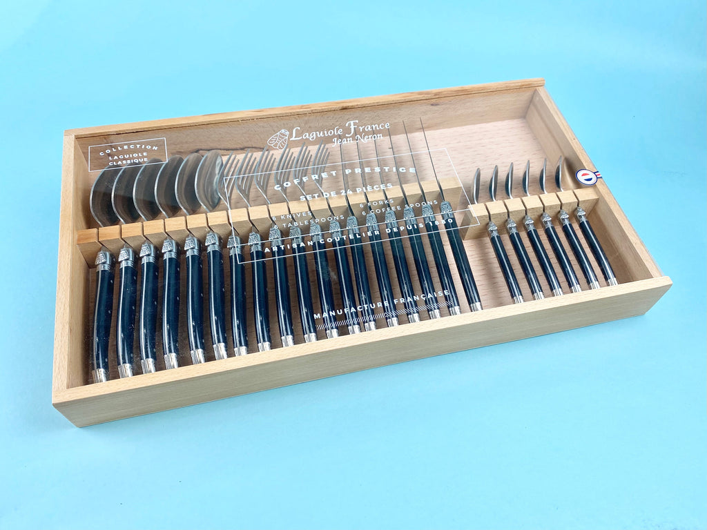 Laguiole stainless steel cutlery set with black handles displayed in beechwood case