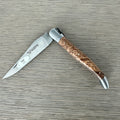 Laguiole ash burl folding knife half open on a grey wood surface