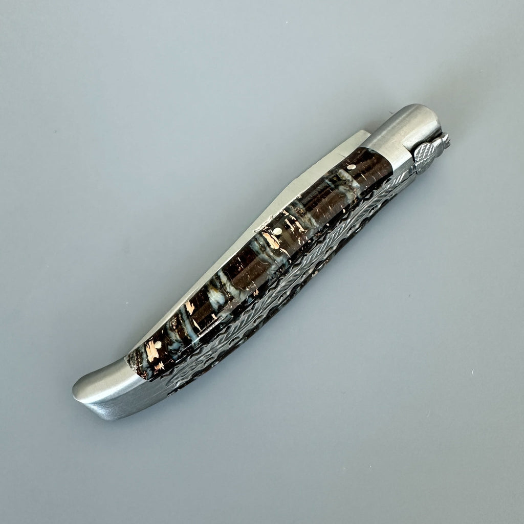 Closed knife on a pale grey surface